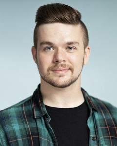 beareded man with pompadour and green plaid shirt with black t-shirt